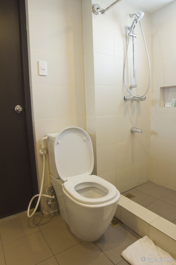 A bathroom with a toilet, a shower, and a bathtub. - Copacabana Apartment Hotel (Pasay)