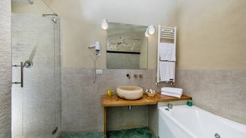 Ein Badezimmer mit Duschkabine aus Glas, einem Holzkosmetikschrank mit Waschbecken, einem Spiegel und einer weißen Badewanne.