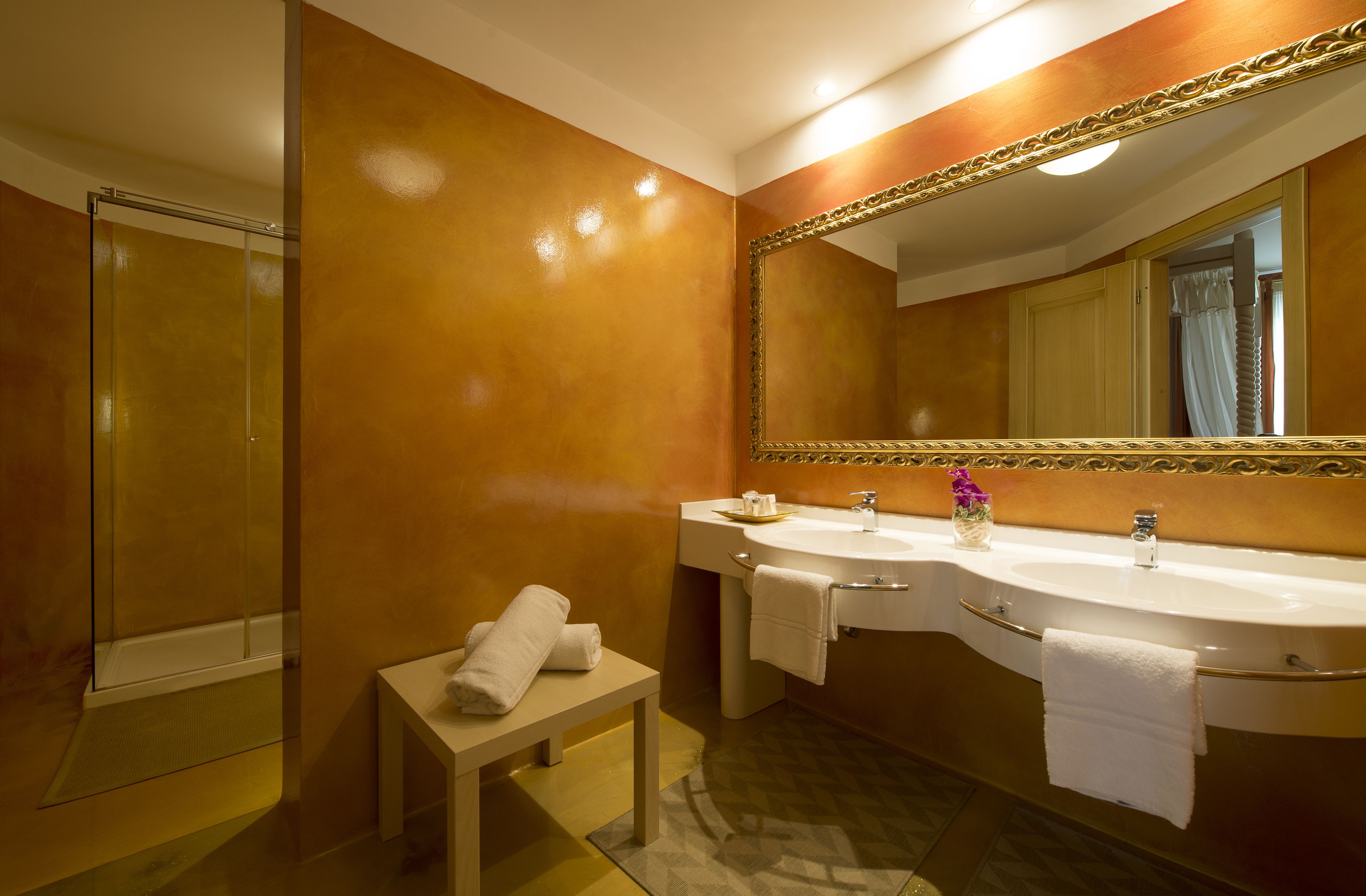 A bathroom with two sinks, a large mirror, and a shower.