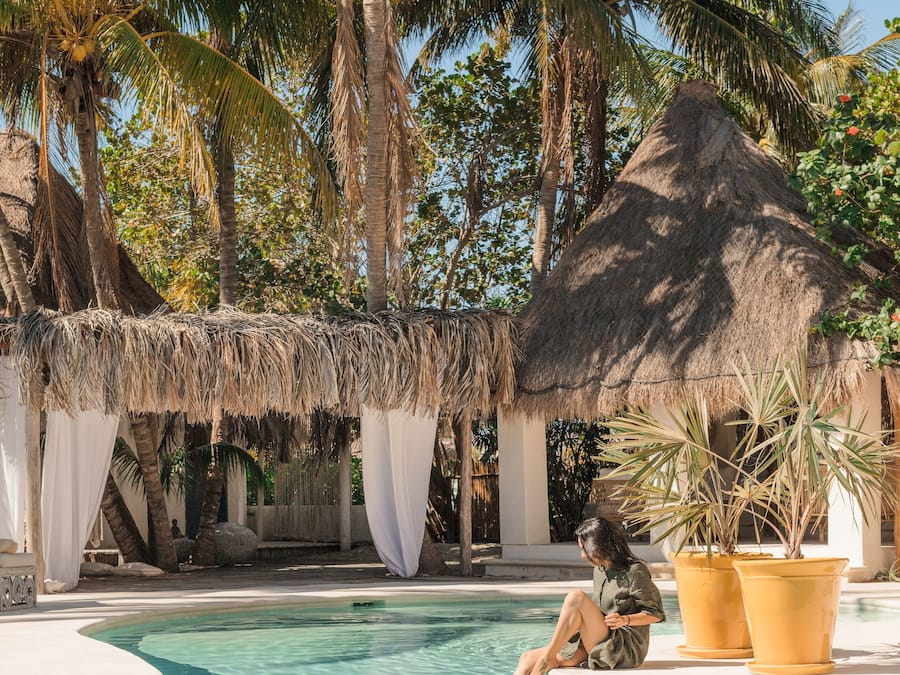 Una piscina al aire libre, sombrillas, sillones reclinables de piscina