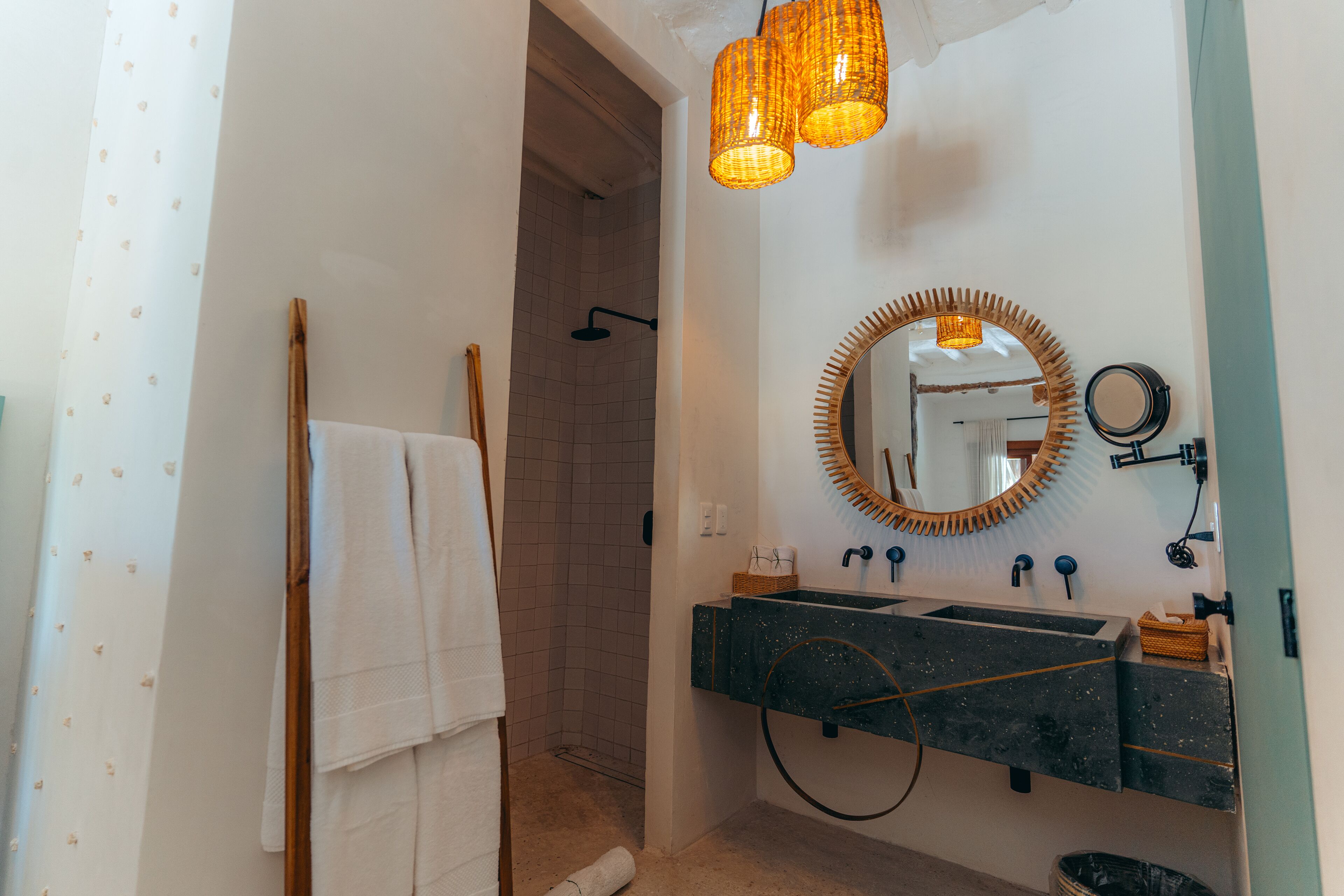 A bathroom with a shower, a sink with a mirror, and a towel rack.
