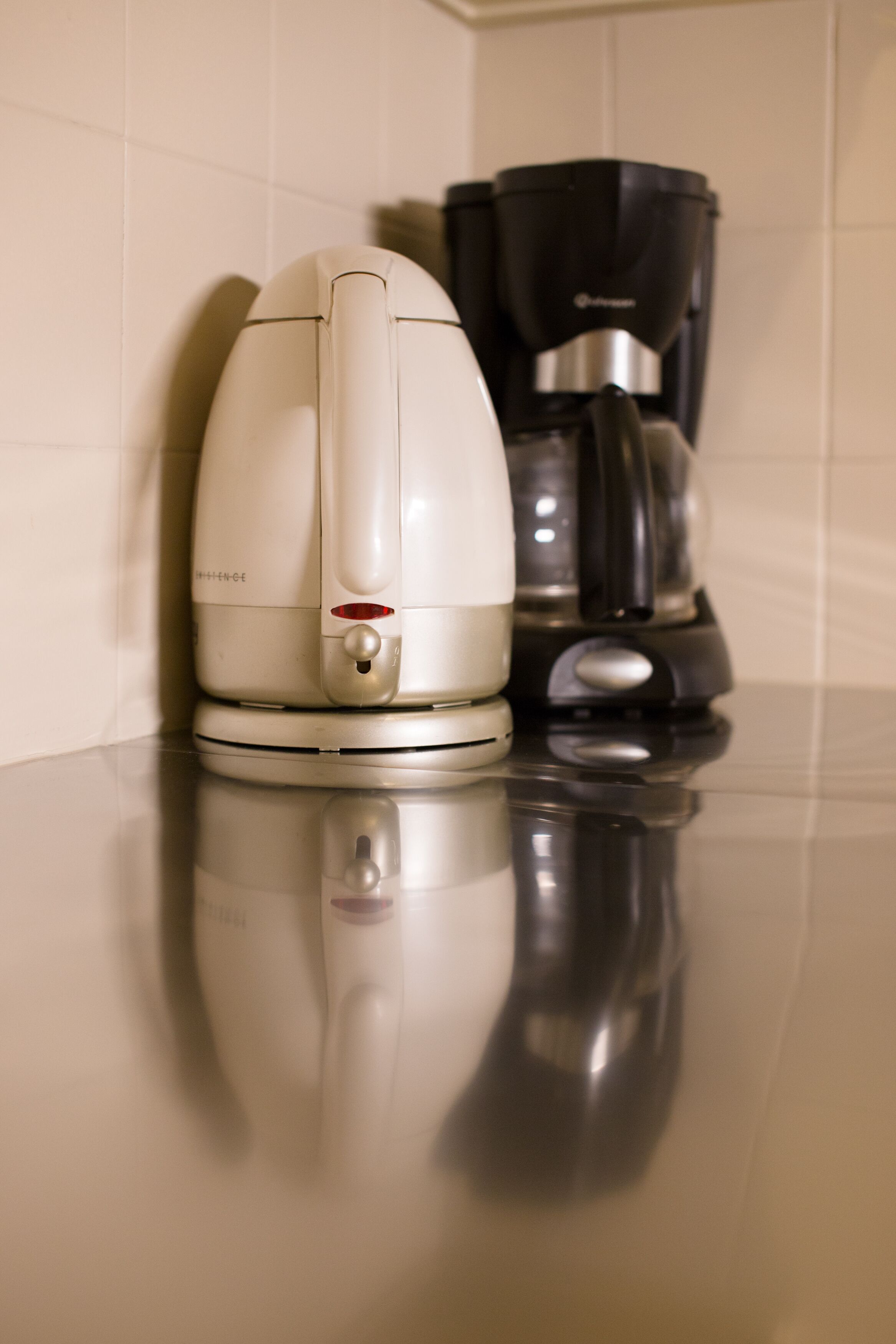 A coffee maker and a drip coffee pot on a kitchen counter.