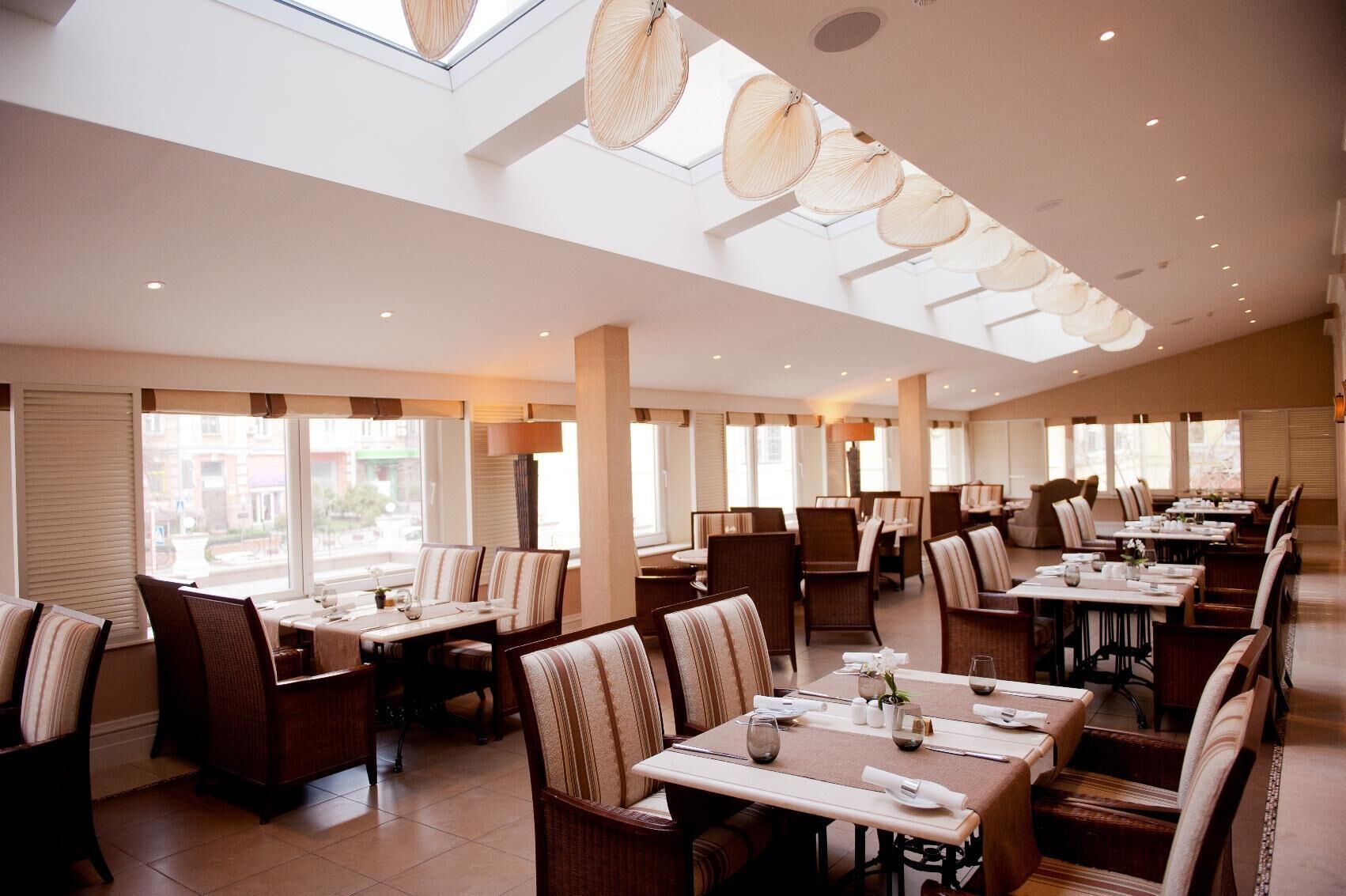 Ein großzügiges Restaurant mit hohen Decken, großen Fenstern und modernen Möbeln.