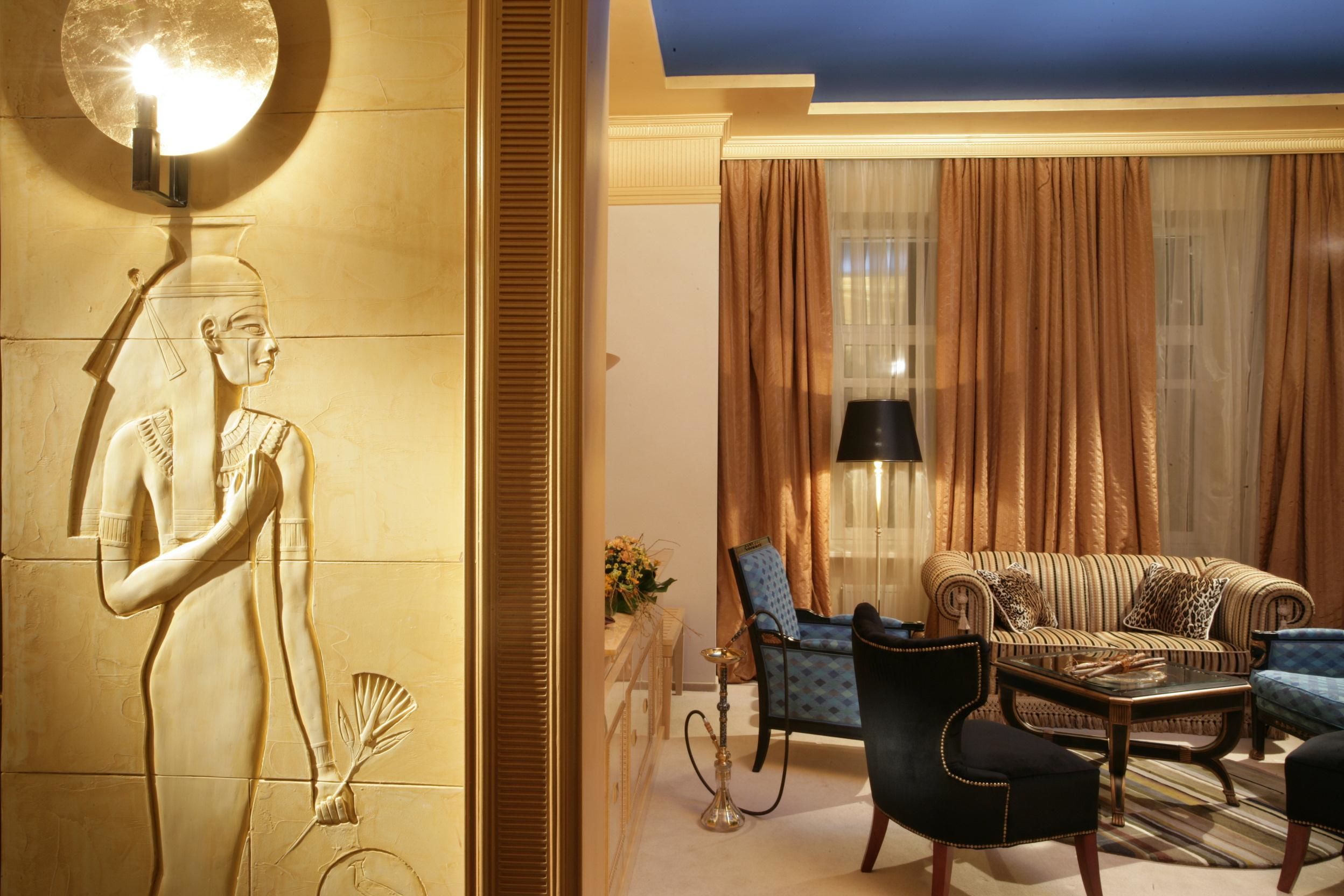 A luxurious living room with a sofa, armchairs, and a coffee table.