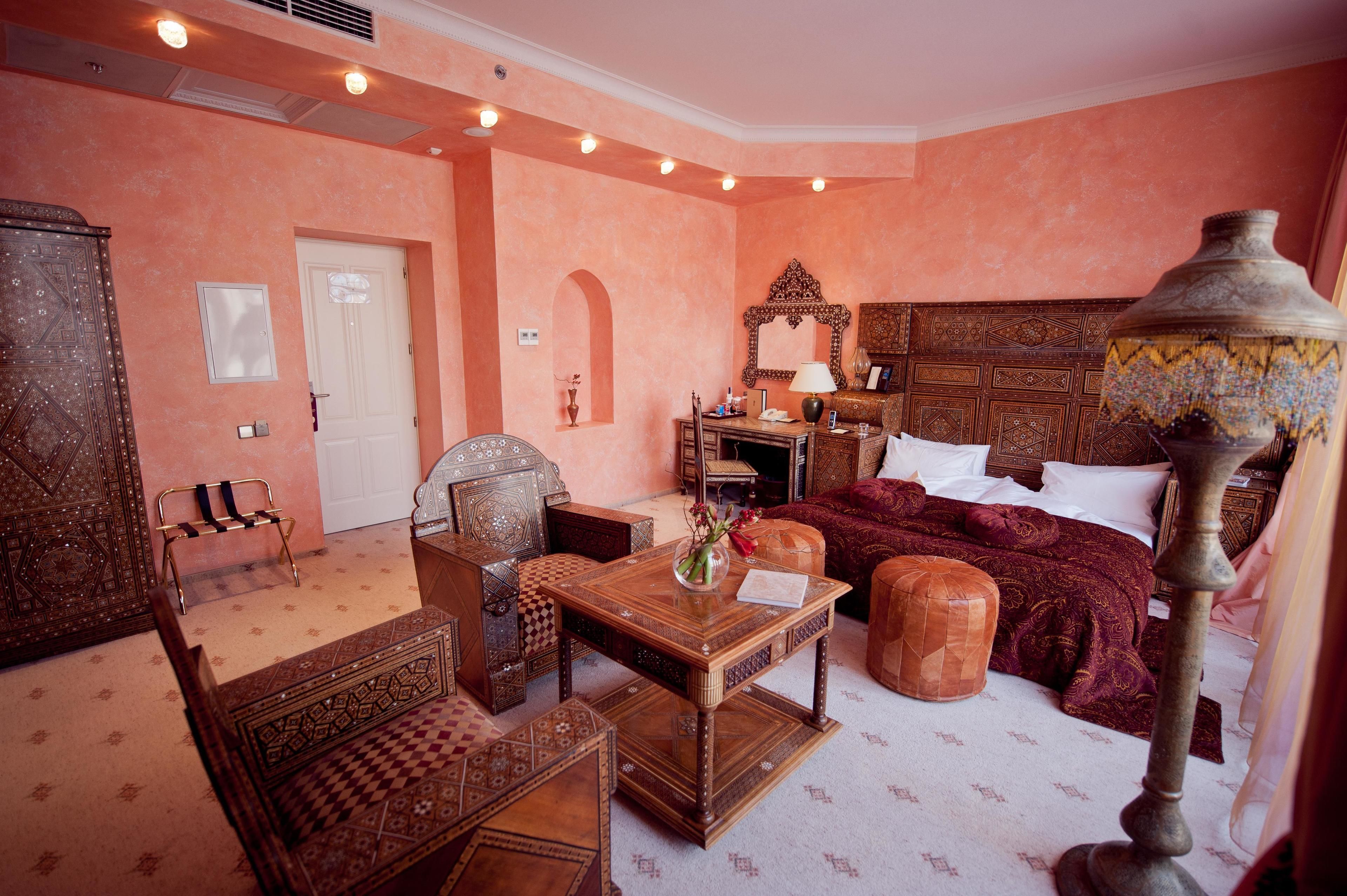A traditional room with a bed, wooden furniture, and a decorative lamp.