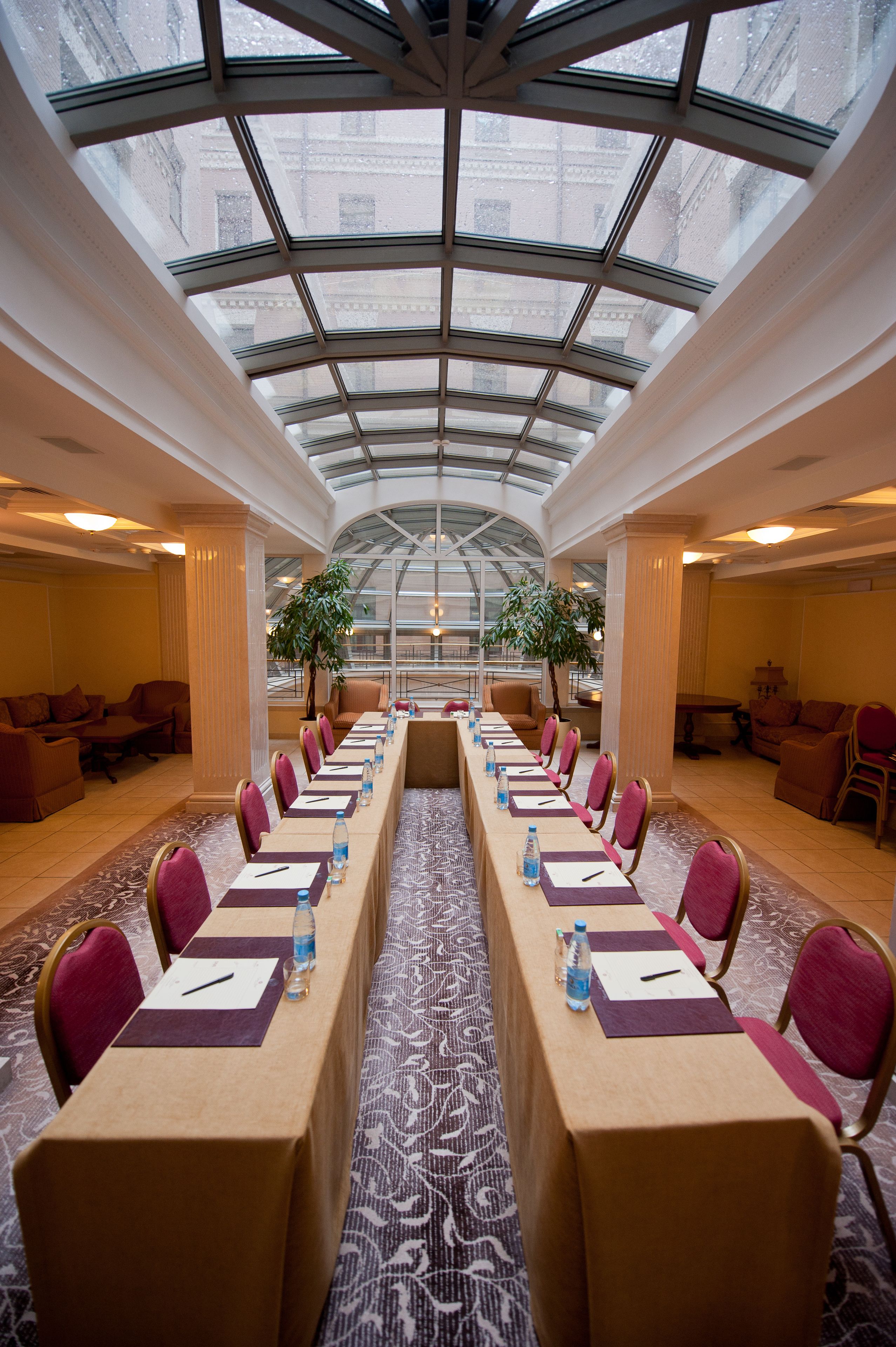 Une salle de conférence avec une longue table, des chaises et un plafond en verre.