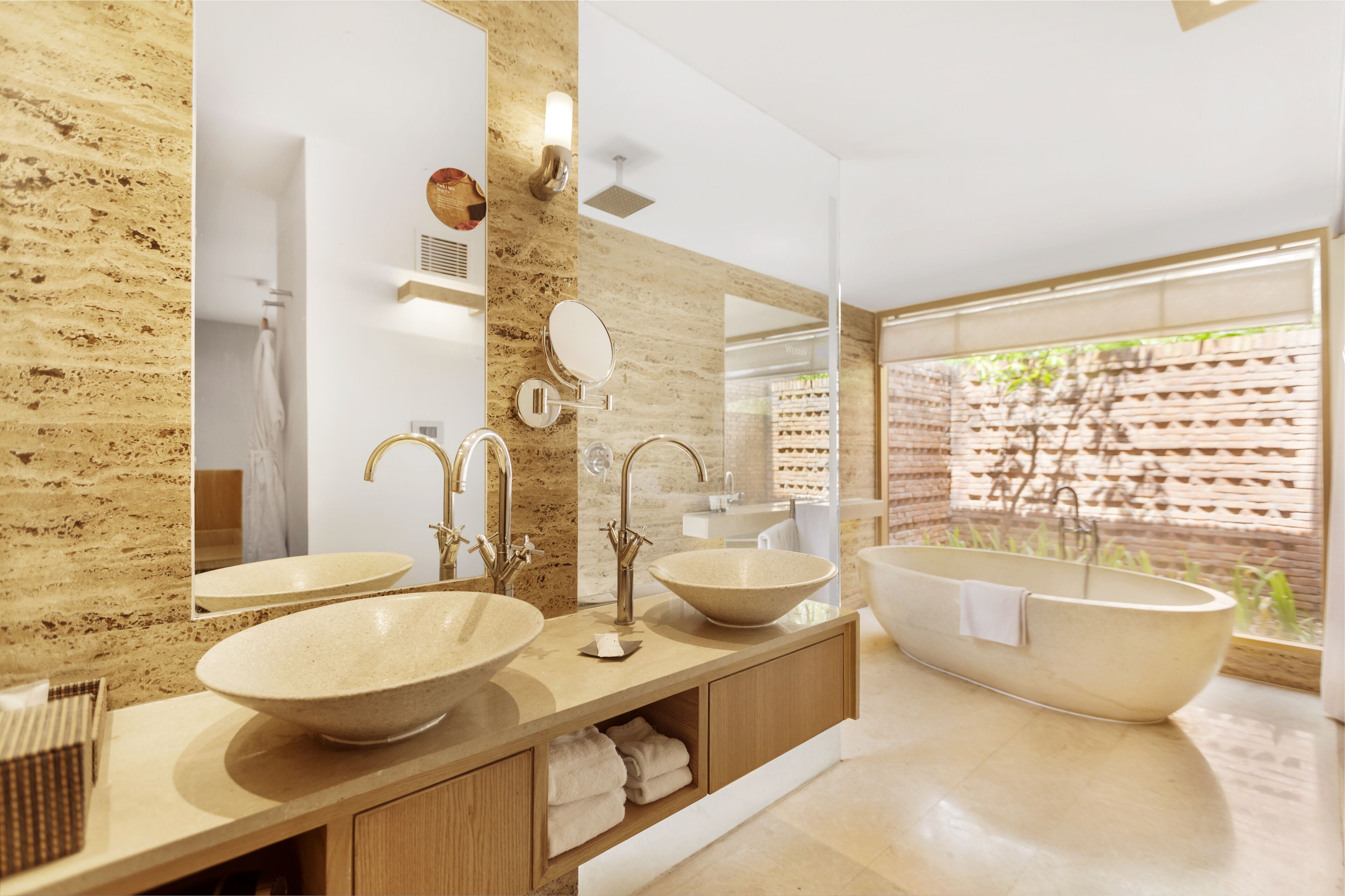 Une salle de bain moderne avec deux grands lavabos, une baignoire sur pieds et un grand miroir.