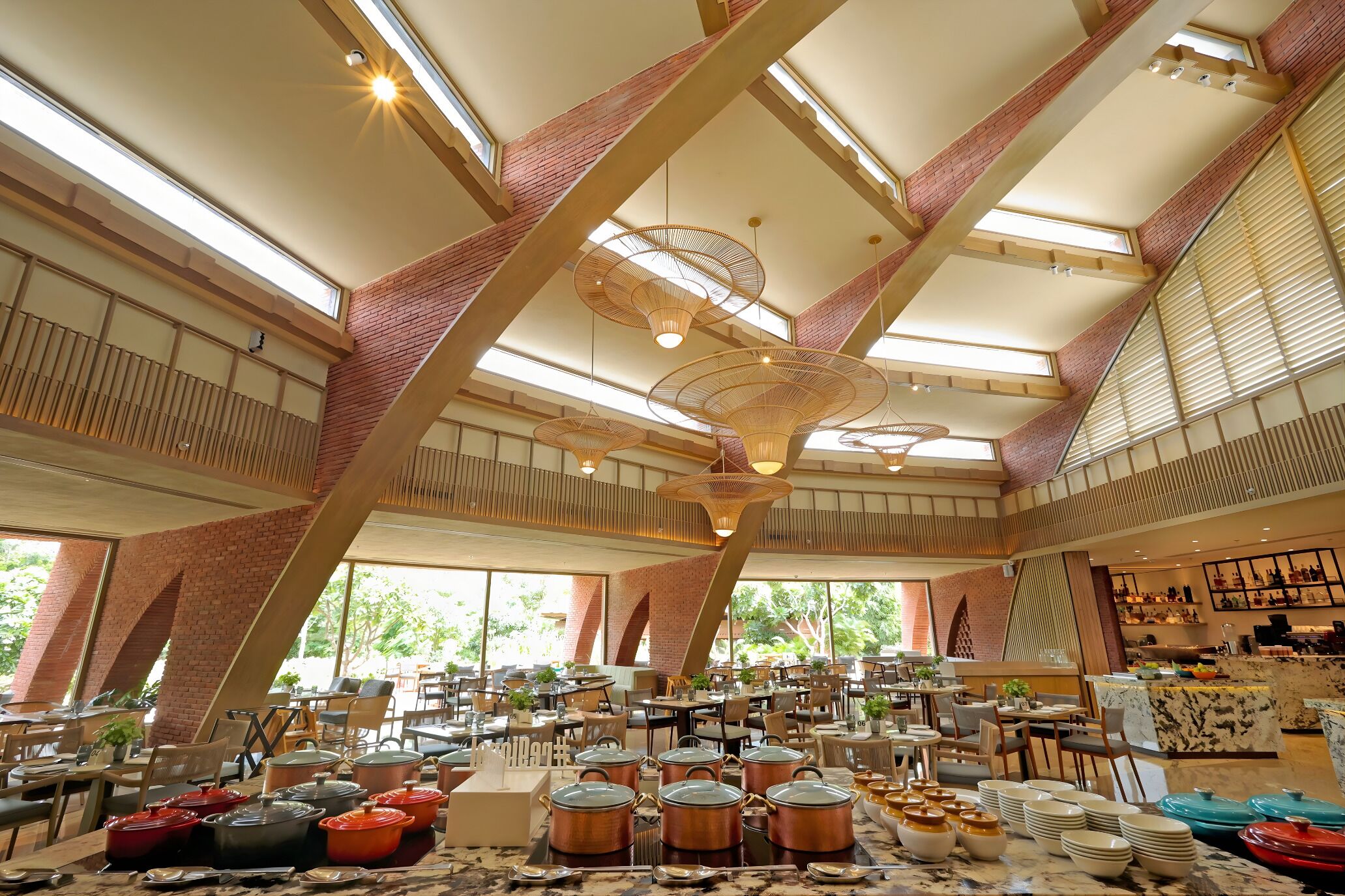 A spacious restaurant with high ceilings, large windows, and a variety of seating arrangements.