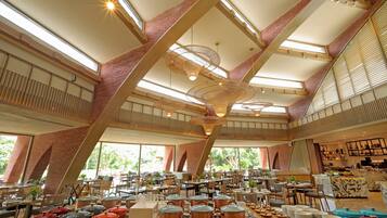 Un restaurant spacieux avec de hauts plafonds, de grandes fenêtres et différents types d’aménagements pour s’asseoir.