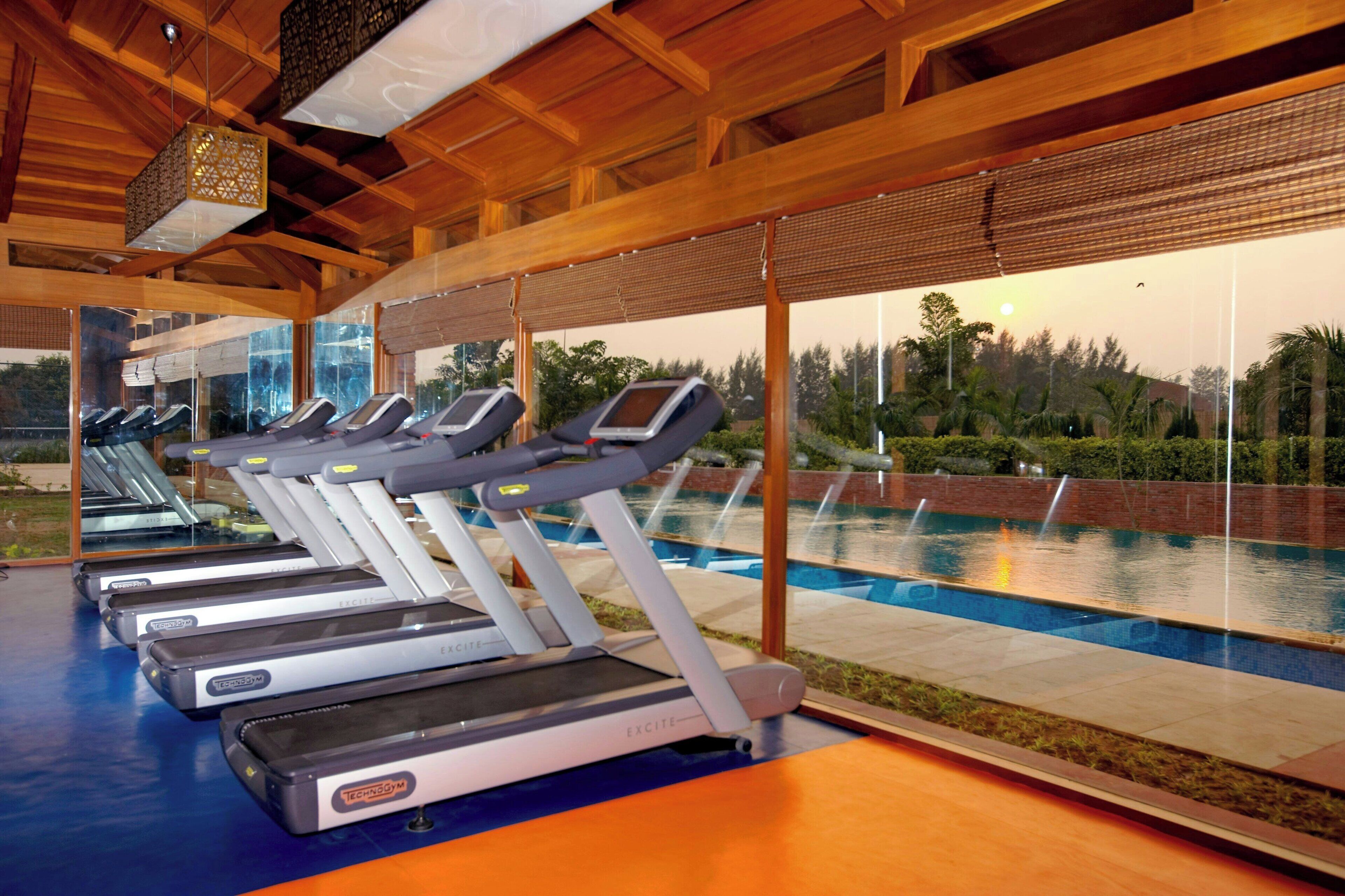 Un gimnasio con cintas de correr y una zona de piscina.