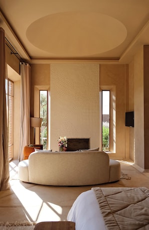 Un dormitorio con una cama grande, un sofá, una chimenea y un televisor.