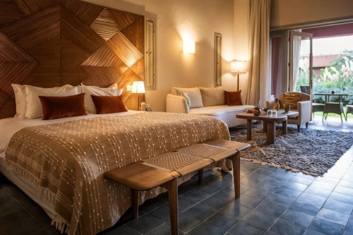 Una habitació d'hotel amb un llit gran, un sofà, una taula petita i una panxa.