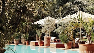 Una piscina al aire libre, camas de piscina gratis, sombrillas