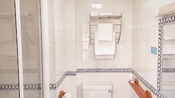 Un baño con inodoro, lavabo y ducha.