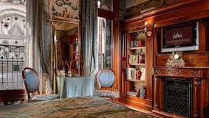 A room with a large mirror, a fireplace, and a bookshelf.