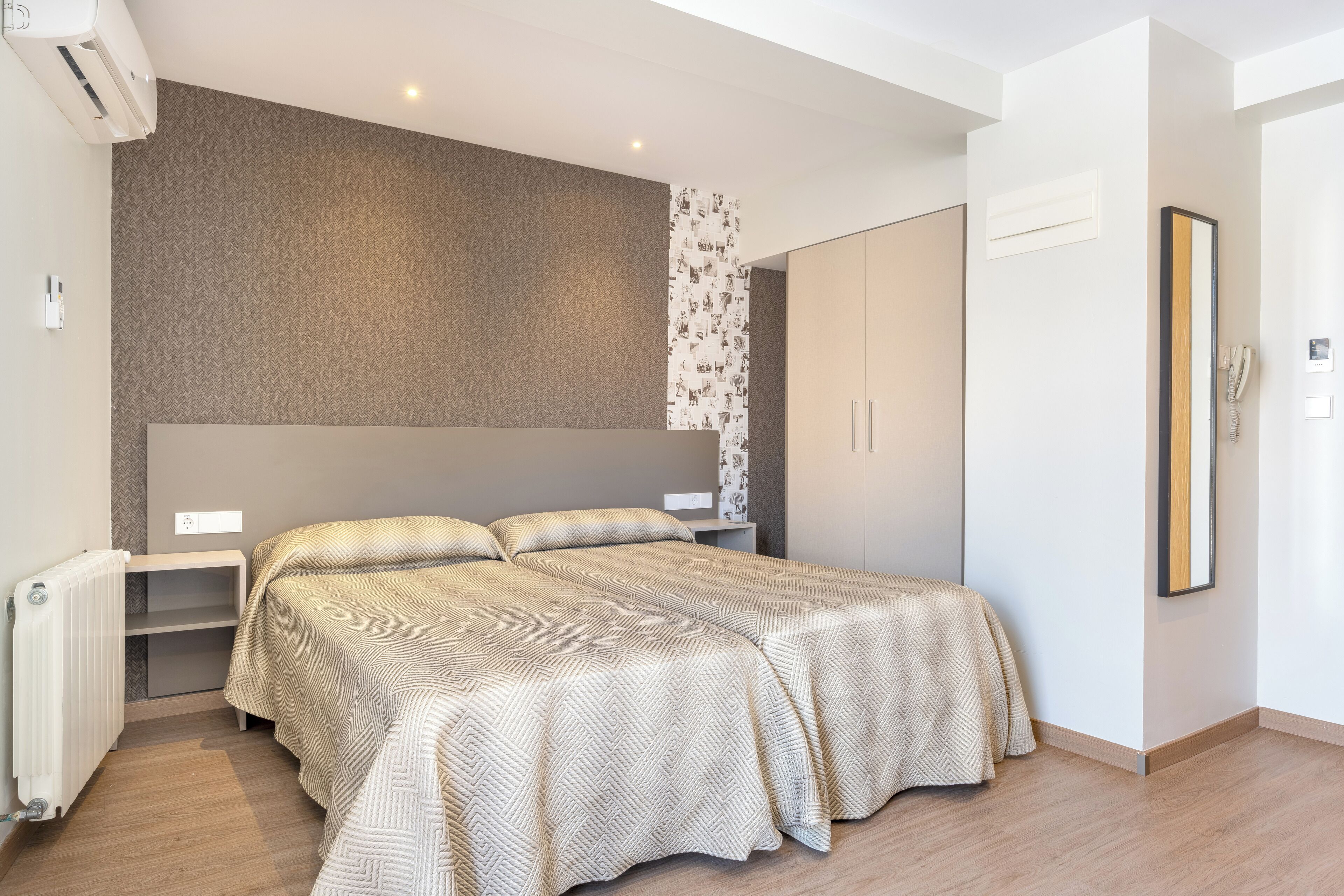 Ein modernes Schlafzimmer mit einem großen Bett, einem eingebauten Kleiderschrank und einer Heizung.