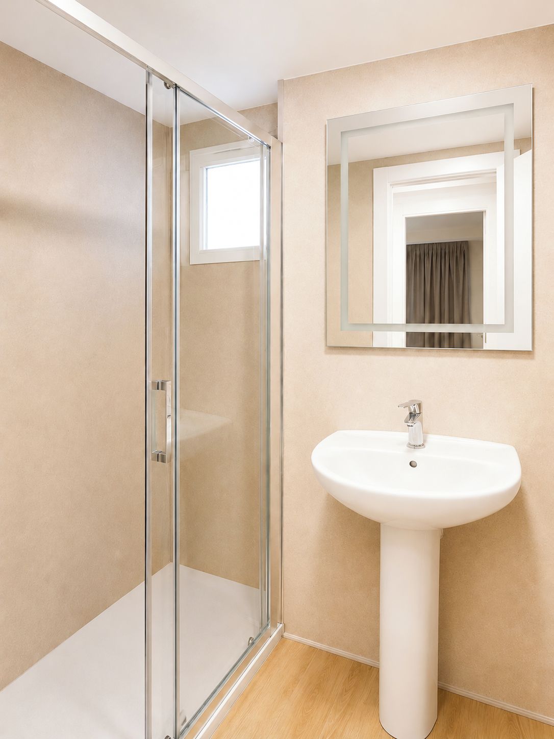 Een badkamer met een douchecabine van glas, een wit zuilwastafel en een spiegel met een kleinere spiegel erin.