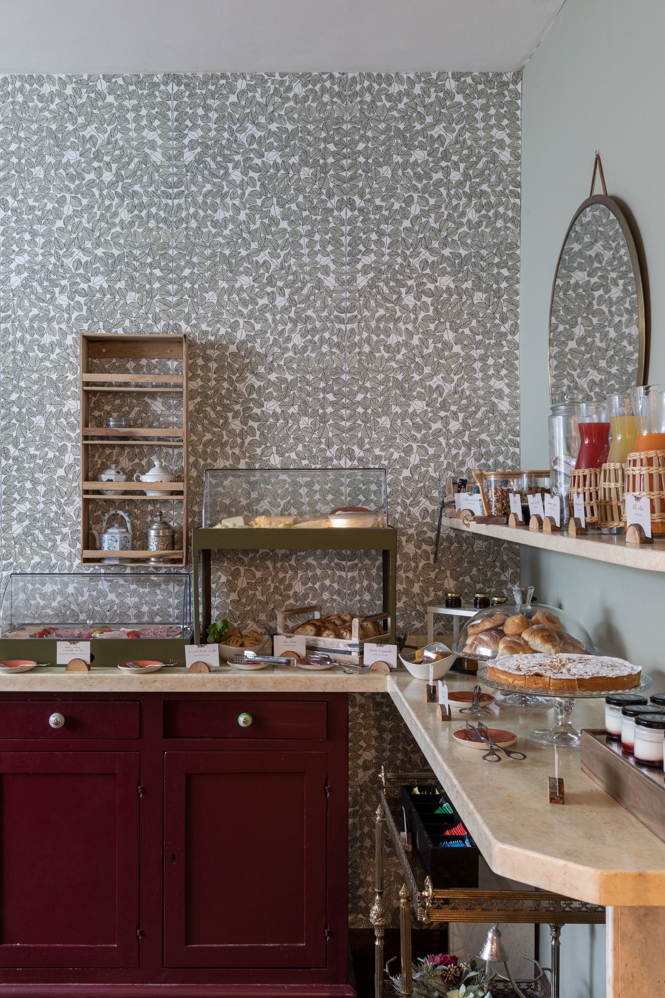 A bakery counter with pastries, a display case, and a mirror on the wall.