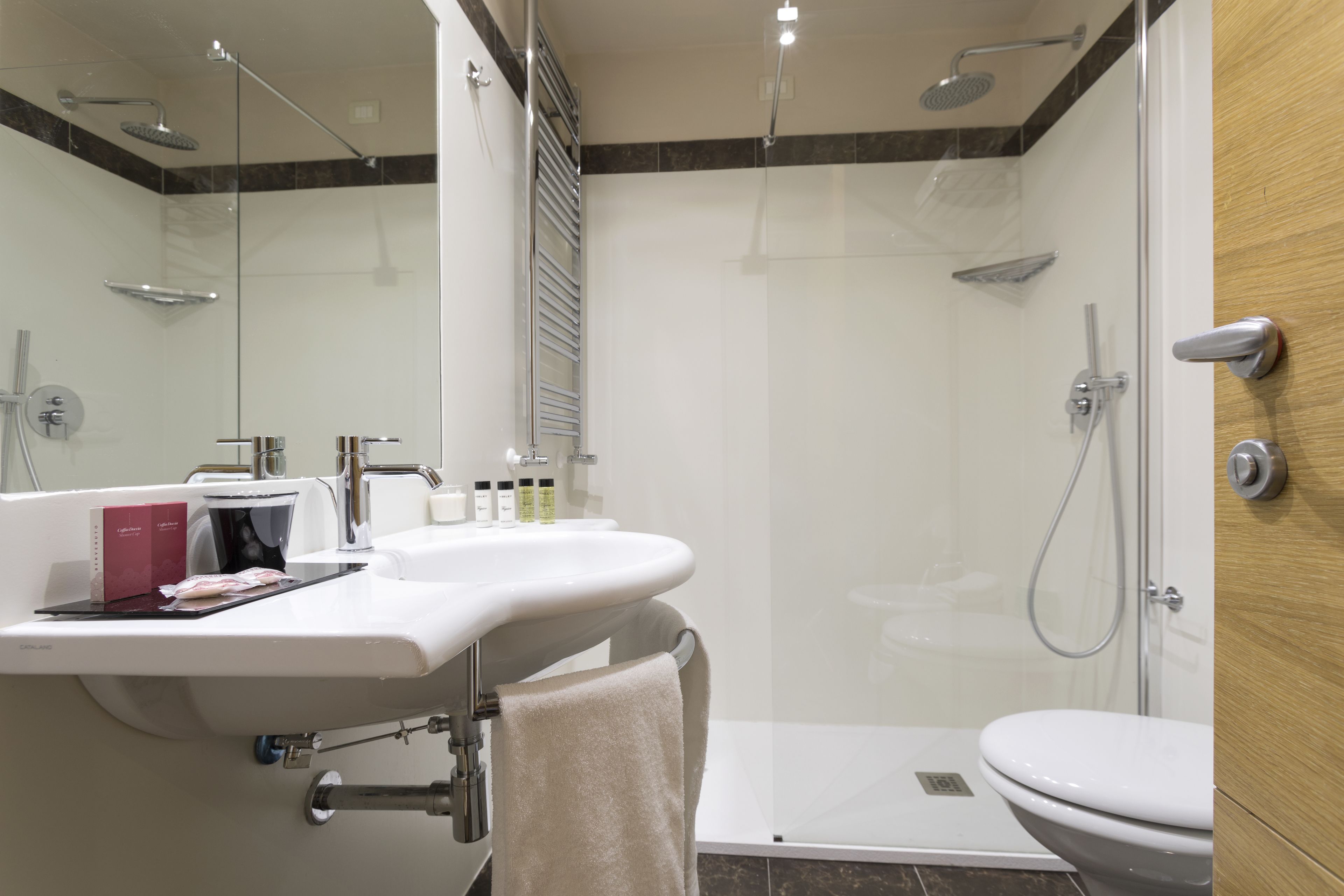 A modern bathroom with a shower, toilet, and sink.