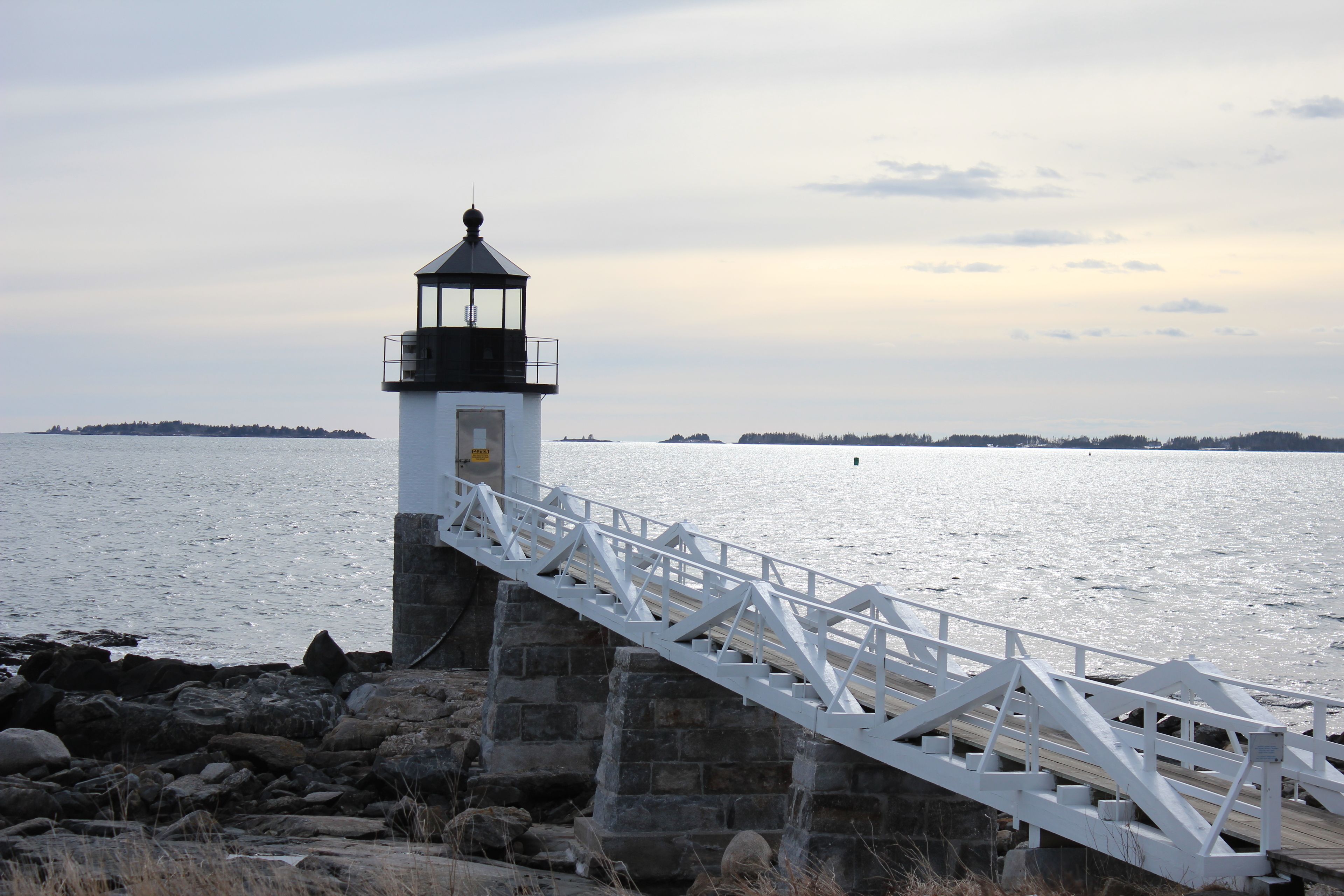 A lighthouse with a white staircase leading to a platform.