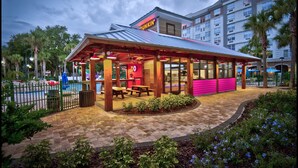 Una tienda DUNKIN' Donuts con terraza y zona de piscina.