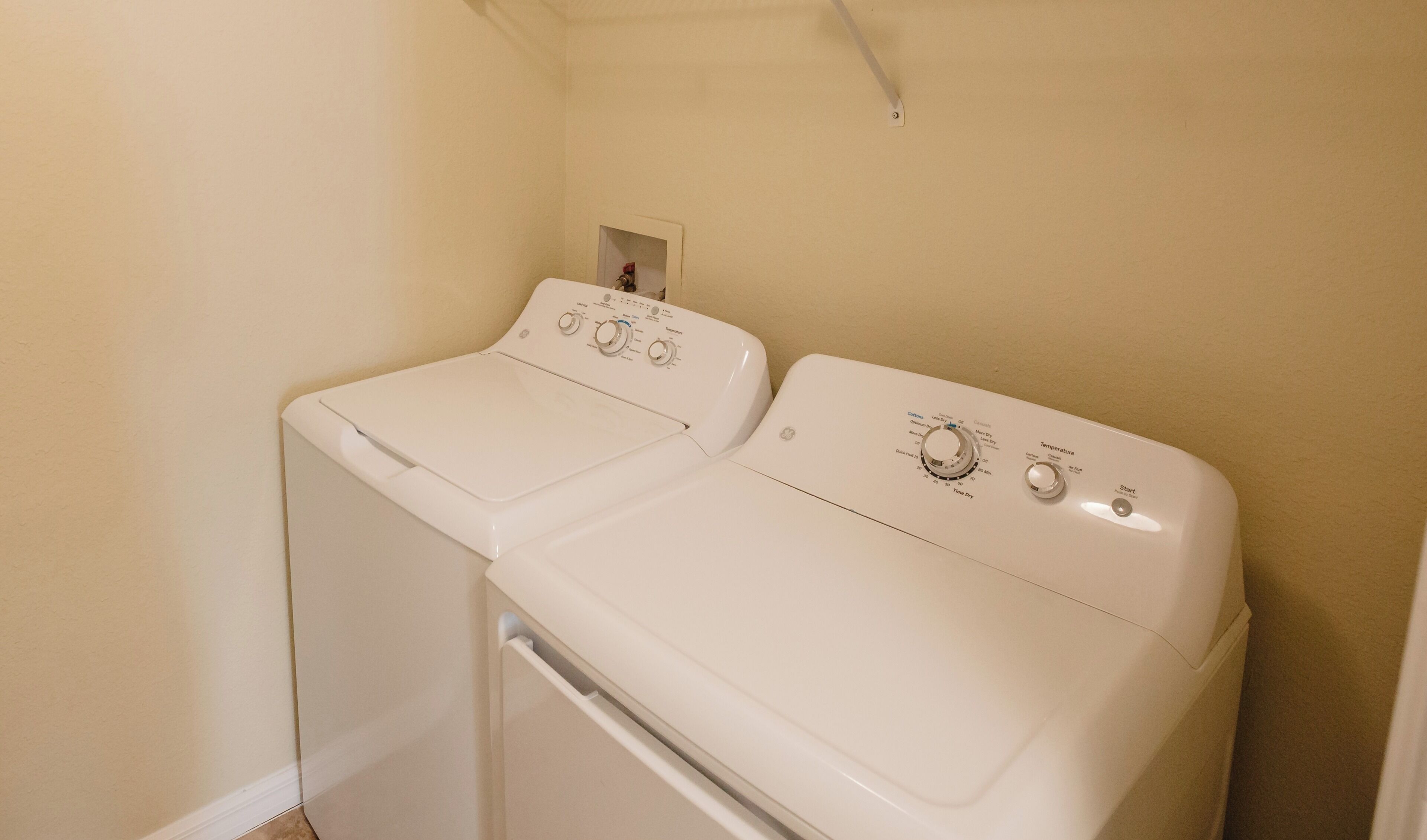 A laundry room with two stacked washing machines and a dryer.