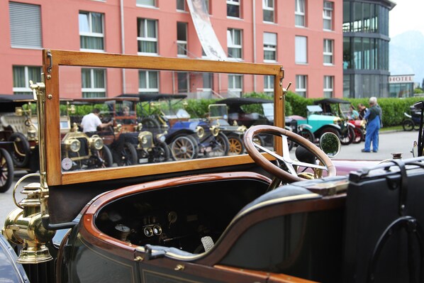 A vintage car with a wooden frame and brass details, parked in front of a building with multiple windows and a sign that reads "HOTEL". - Swiss Heidi Hotel (Maienfeld)