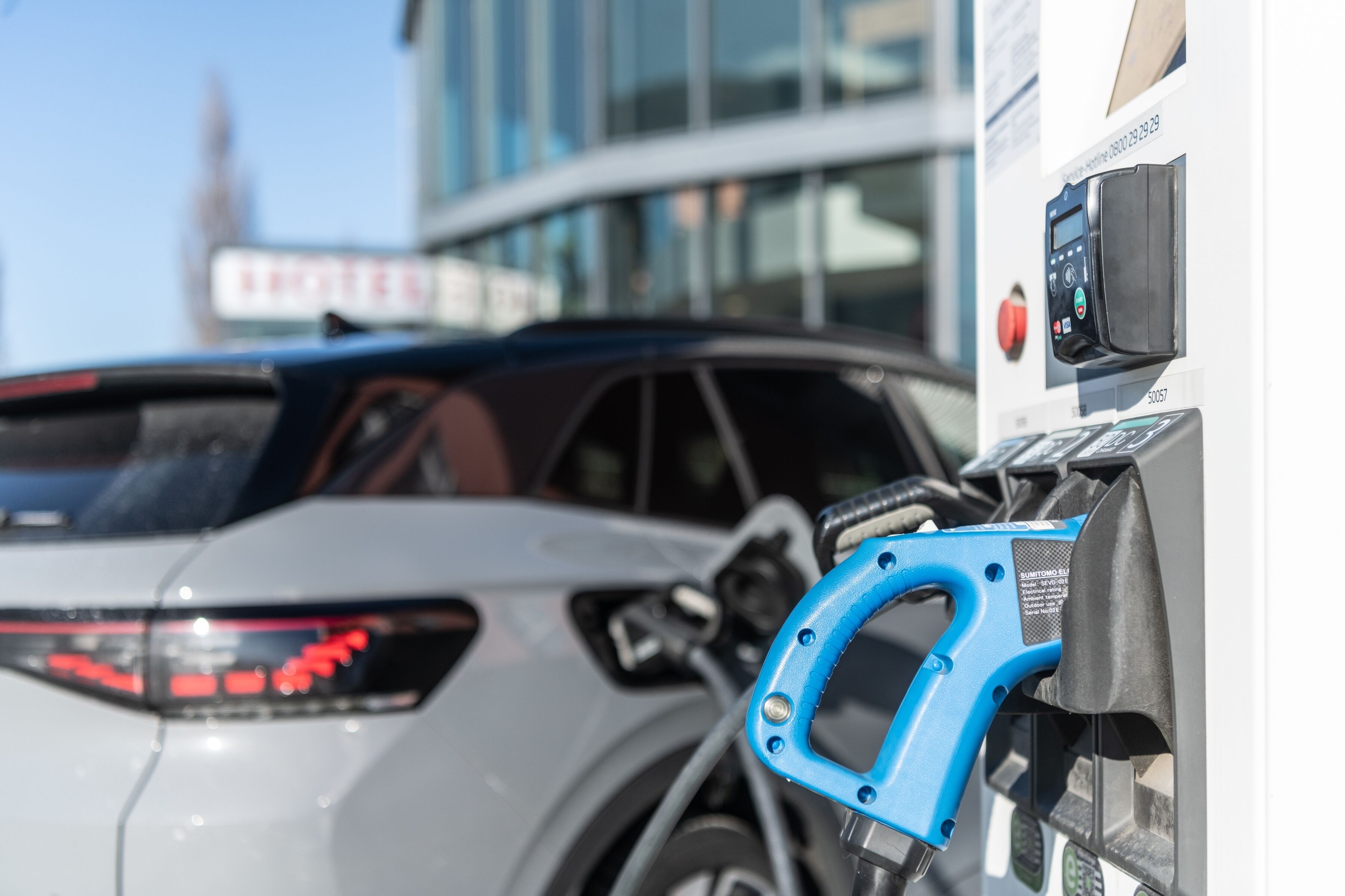 Une voiture en cours de recharge à une borne équipée d’un connecteur bleu.
