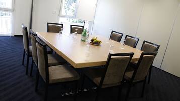 A conference room with a long table, chairs, and a fruit bowl.
