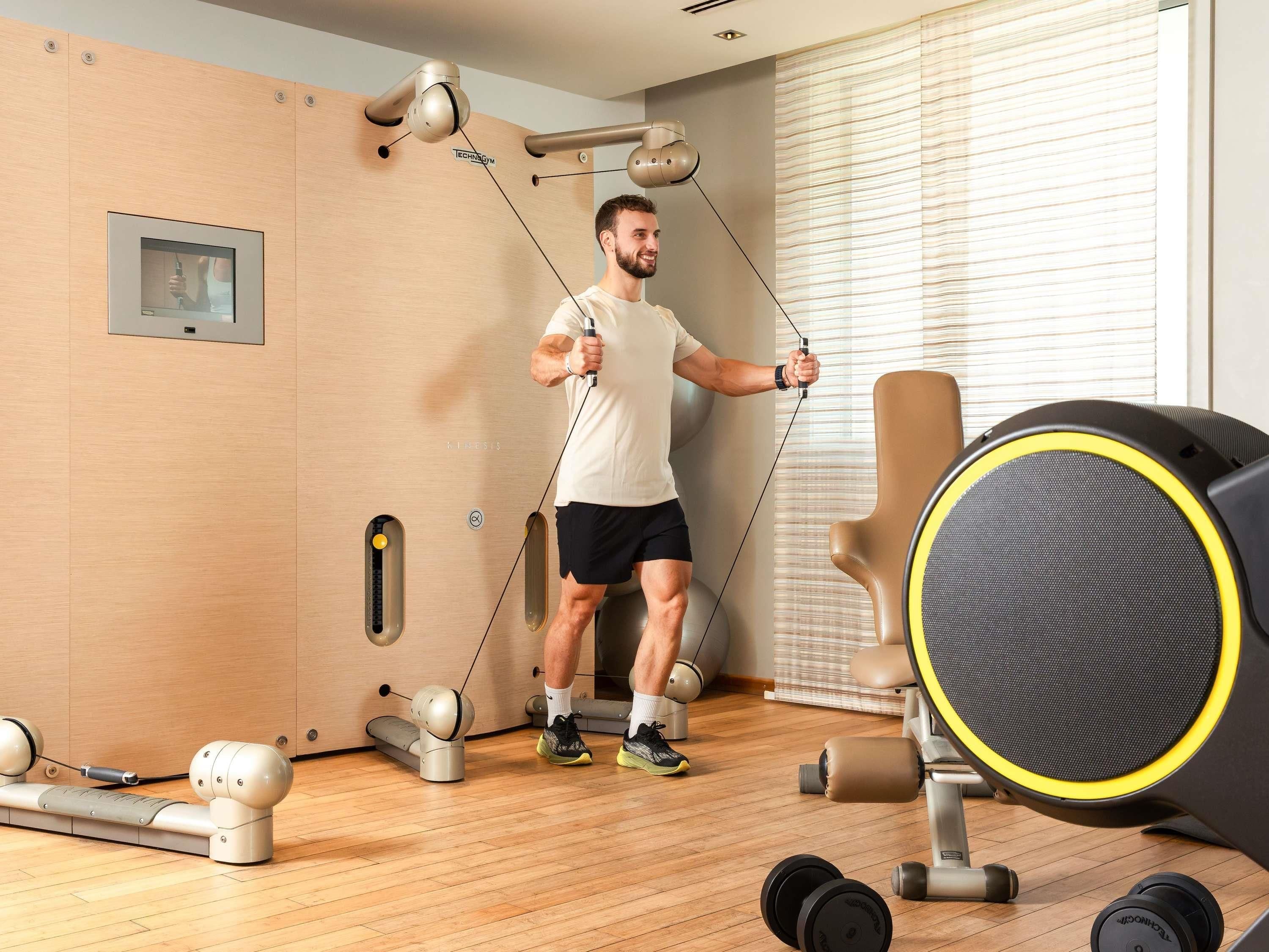 Un gimnasio con equipo de ejercicio, incluyendo una cinta de correr, pesas y bandas de resistencia.