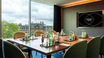 Ein Besprechungsraum mit großem Tisch, Stühlen und Blick auf die Stadt.