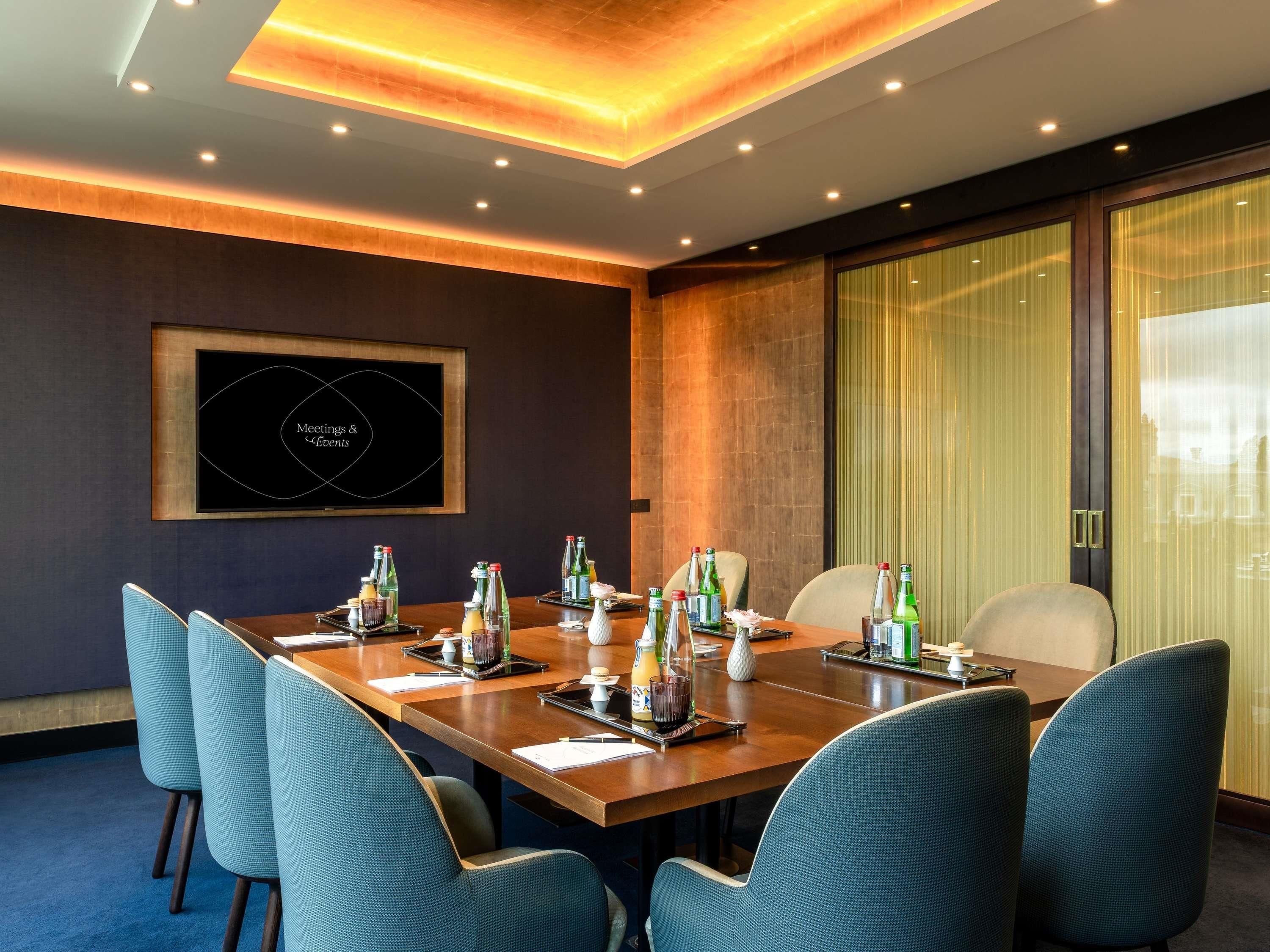A conference room with a long table, chairs, and a framed sign on the wall.