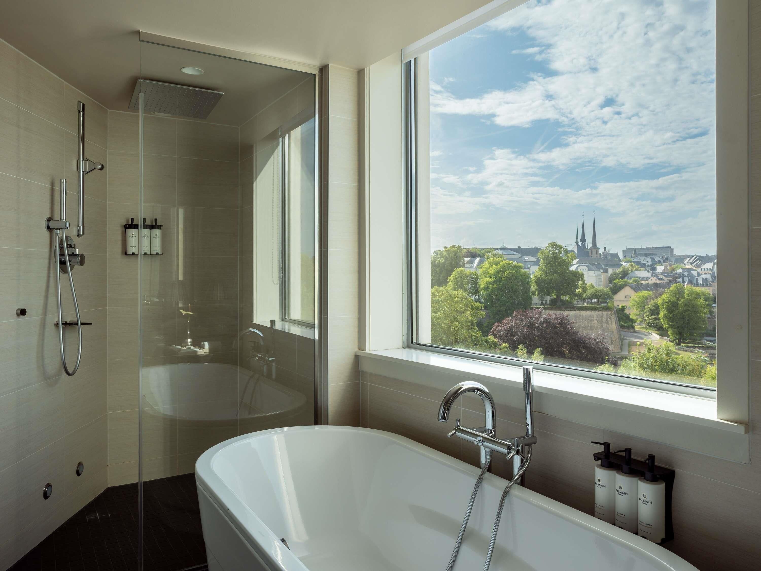 Ein modernes Badezimmer mit Badewanne, Dusche und einer Glaskabine für die Dusche.