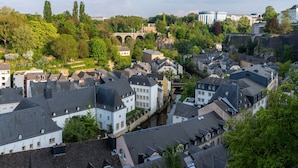 A historic town with traditional architecture, a river, and a bridge in the background. - Sofitel Luxembourg Le Grand Ducal (Luxembourg City)
