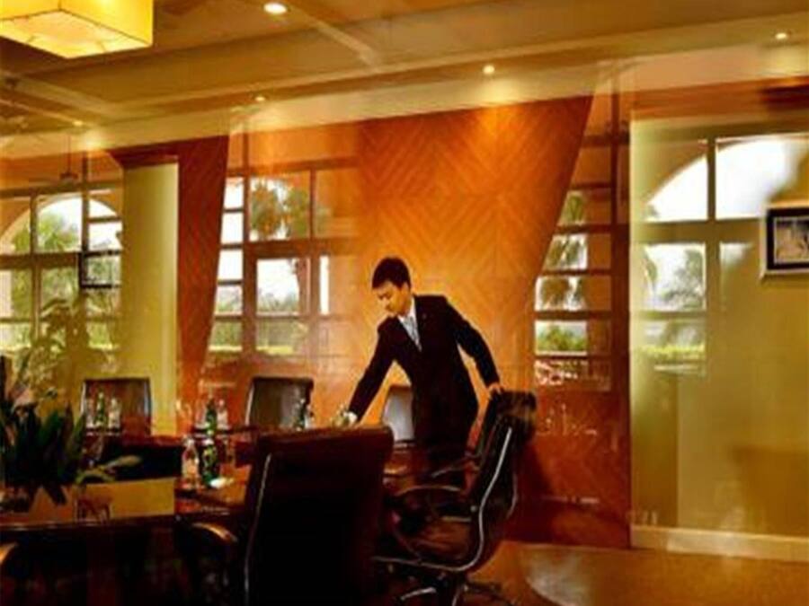 A modern office space with a large wooden panel wall, a desk with a computer, and a chair.