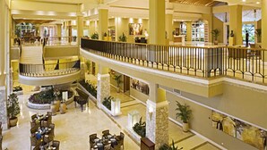 A multi-level hotel lobby with a central staircase, multiple seating areas, and decorative plants. - Hillview Golf Hotel (Dongguan)