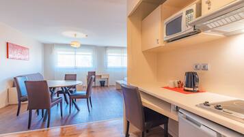 A modern kitchen with a microwave, kettle, and a sink.