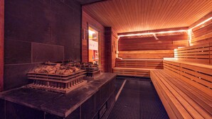 Sauna, jossa on puiset lauteet ja kivilauteista tehty alue.