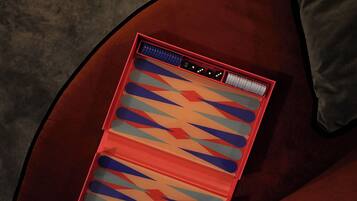 Un sofá de terciopelo rojo con un cojín estampado.
