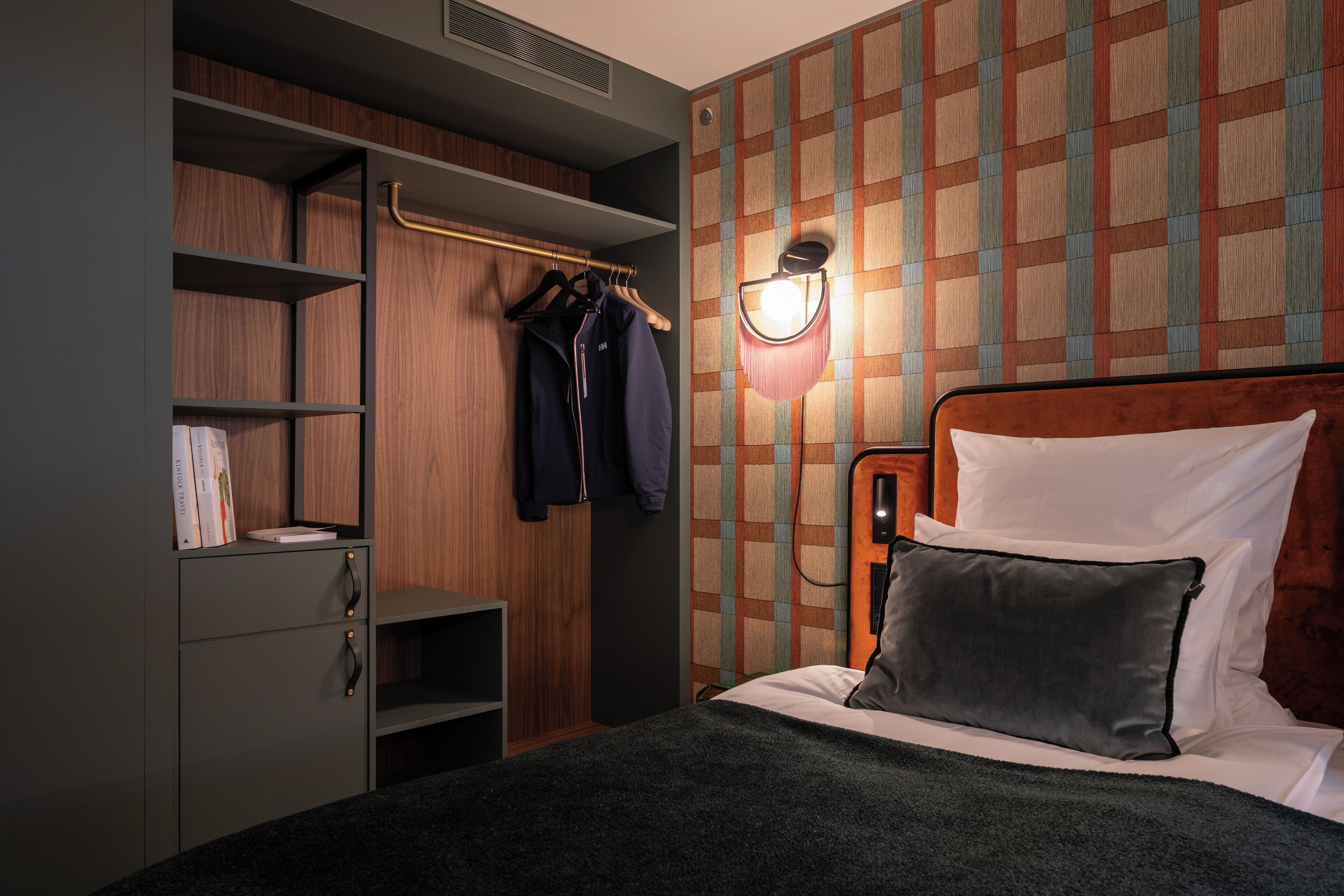 Un dormitorio con cama, armario y perchero.