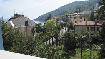 Une ville côtière avec des bâtiments, une vue sur la mer et une végétation luxuriante.