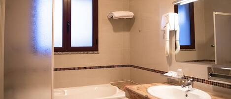 Ein Badezimmer mit Badewanne, Waschbecken, Handtuchhalter und Spiegel.