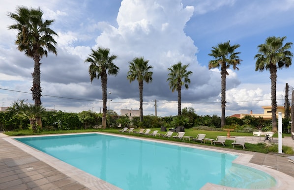 A swimming pool with lounge chairs and palm trees. - Il Tabacchificio Hotel (Gagliano del Capo)