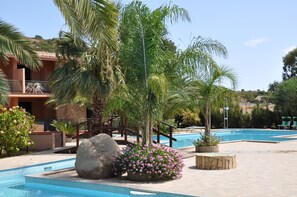 Piscina a l'aire lliure de temporada, para-sols i gandules 