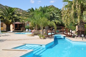 Een seizoensgebonden buitenzwembad en parasols bij het zwembad