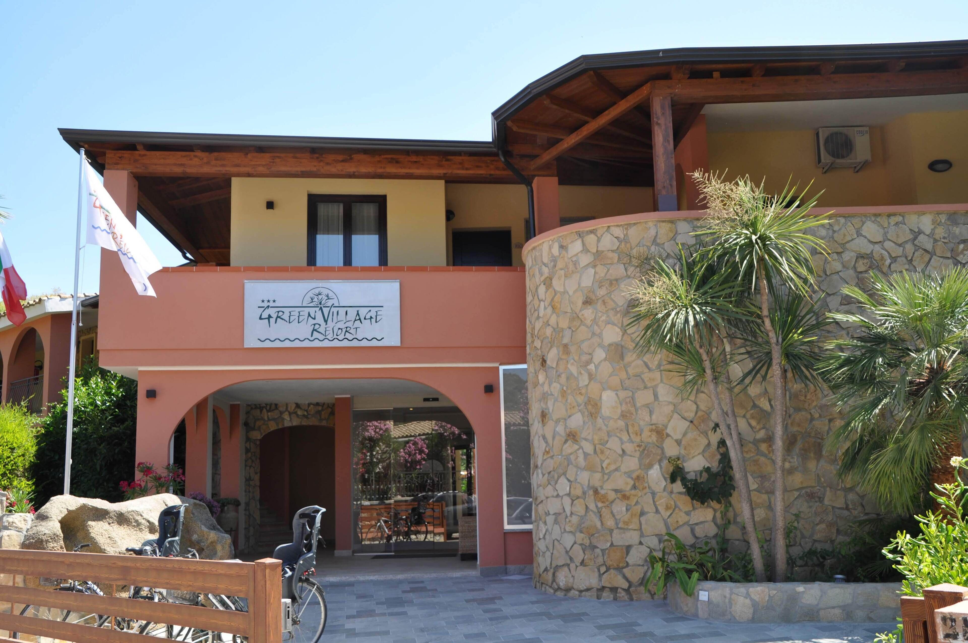 A building with a sign reading "Green Village Resort".