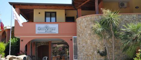 A building with a sign reading "Green Village Resort".