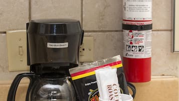 Un coin cuisine équipé d’une machine à café, d’un extincteur et d’un panneau indiquant qu’il s’agit d’une chambre non-fumeur.
