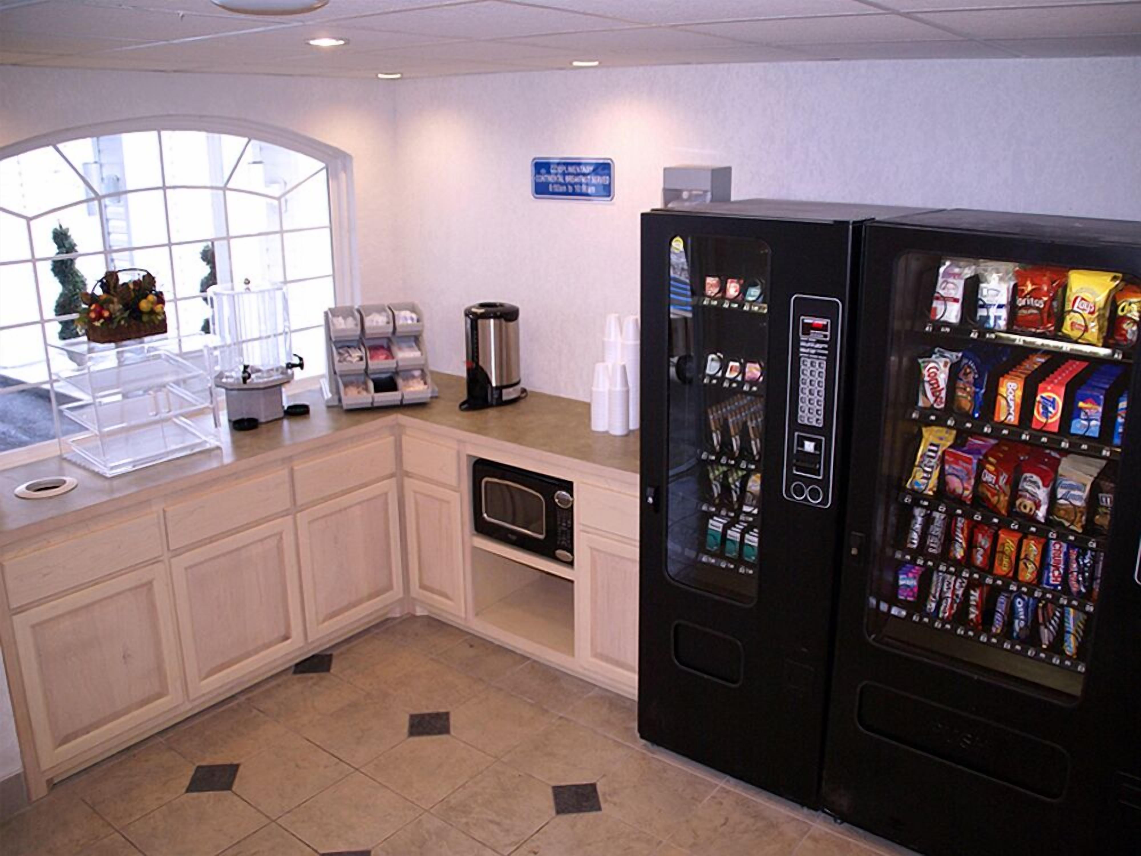 A kitchenette with a coffee maker, a microwave, and a vending machine.