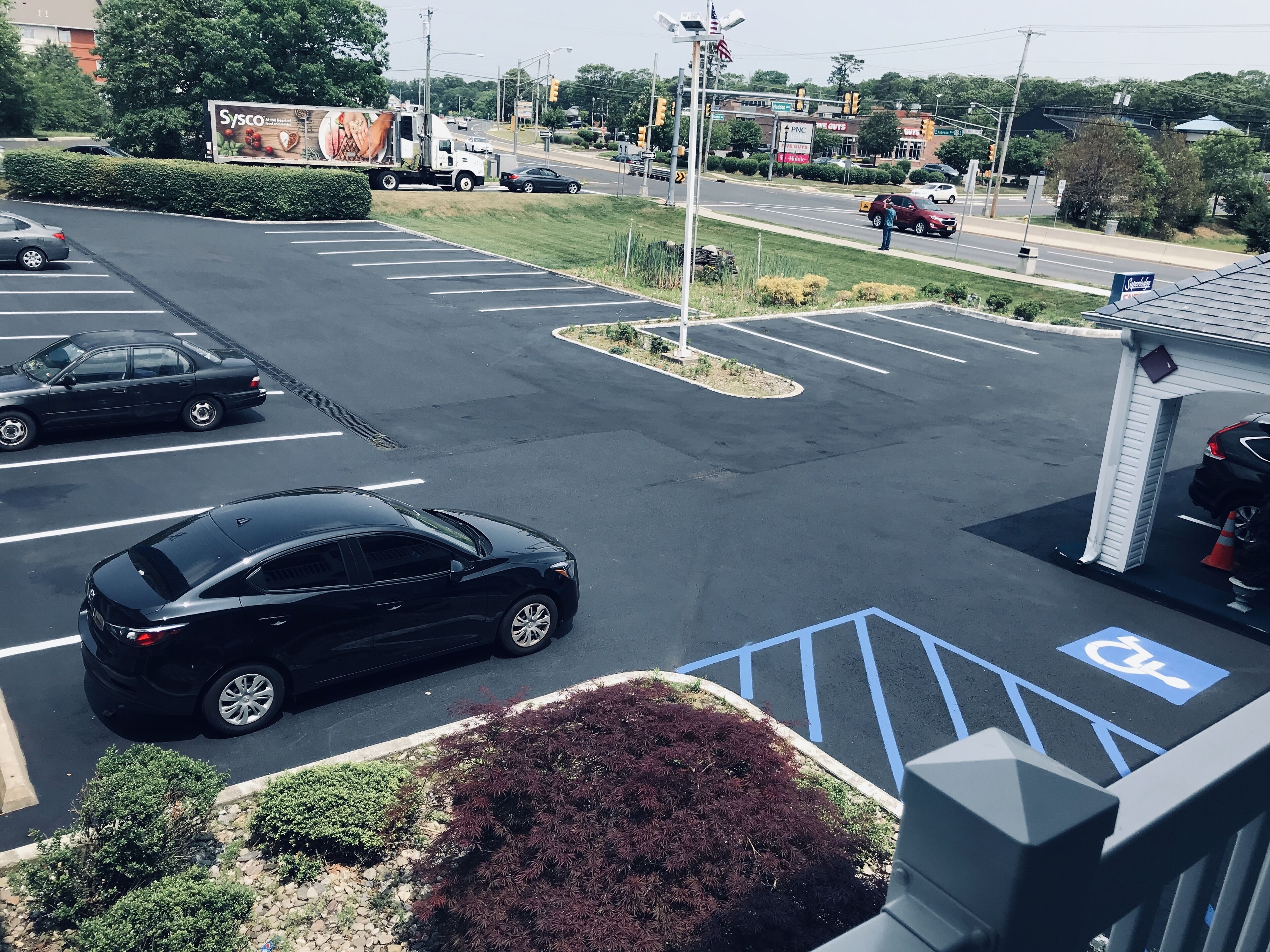 A parking lot with marked handicapped spaces and a building with a signboard.